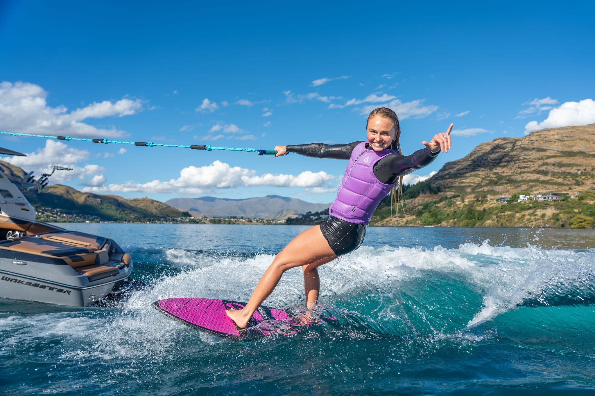 Emma Galusha carving the wave behind a Malibu wake boat on Lake Wakatipu