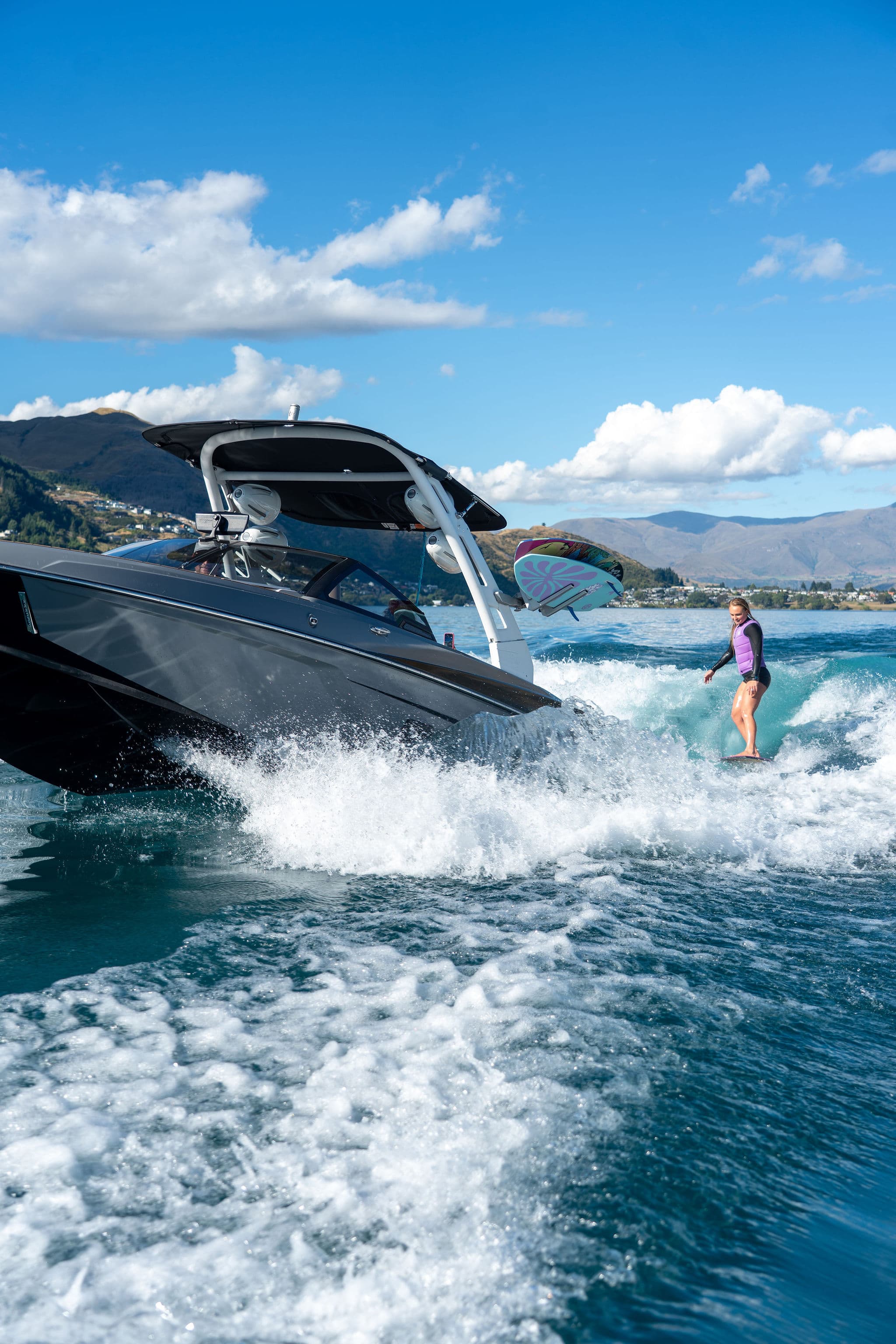 Wake boat towing a surfer with the wave set up correctly